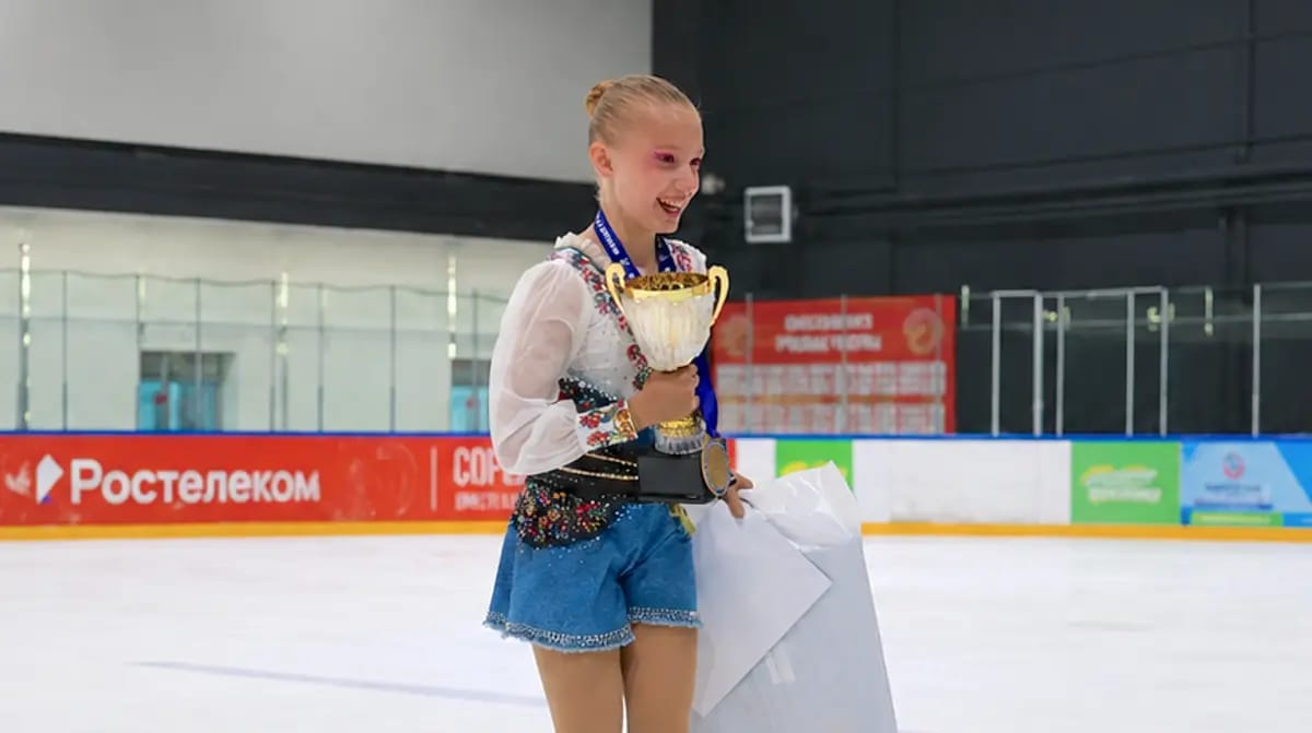 Фигуристка с кубком и медалью на соревнованиях